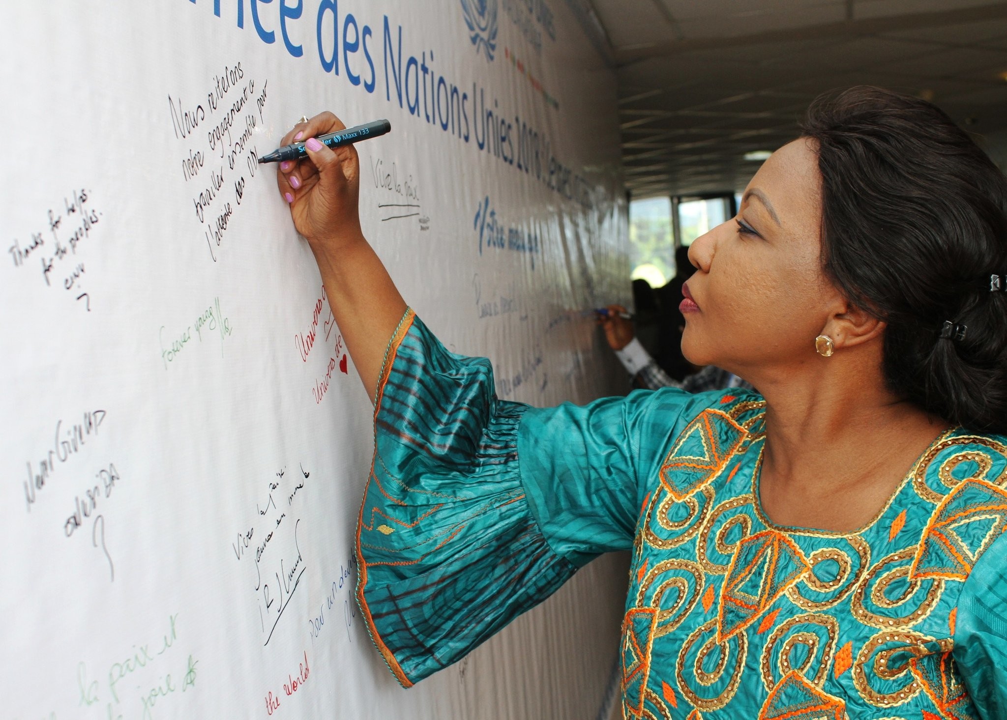 Violeta Kenyana Kakyomya signs a pledge.