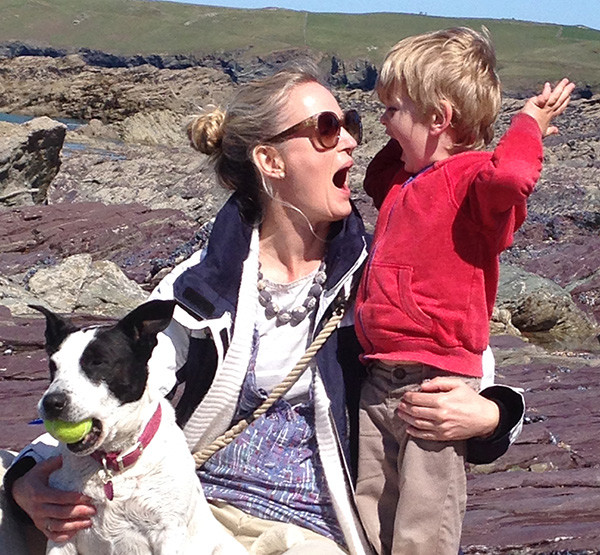 Amy Clarke plays along her child and dog
