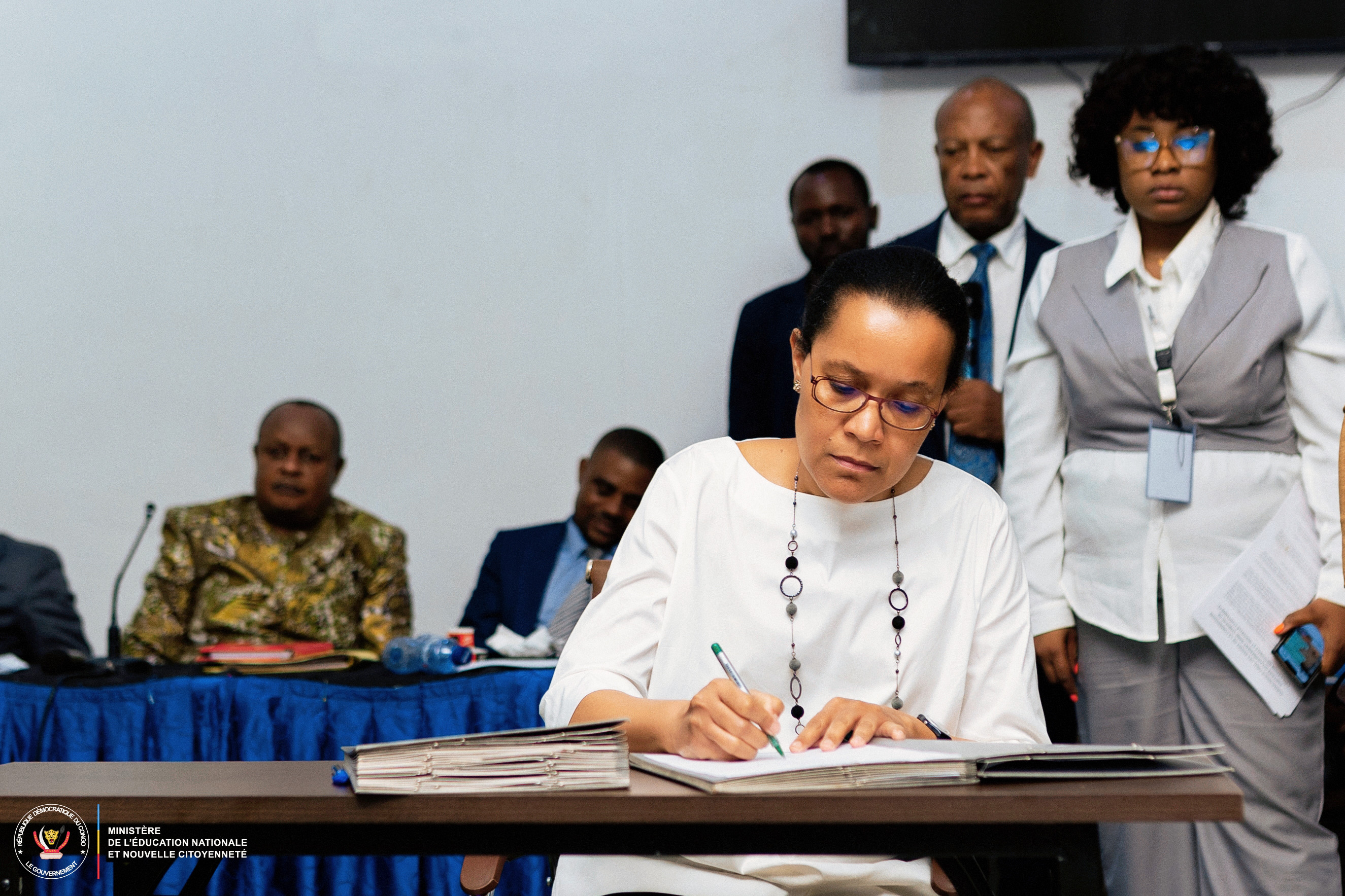 Raïssa Malu is Minister of State, Minister of National Education and New Citizenship for the DRC signing a document
