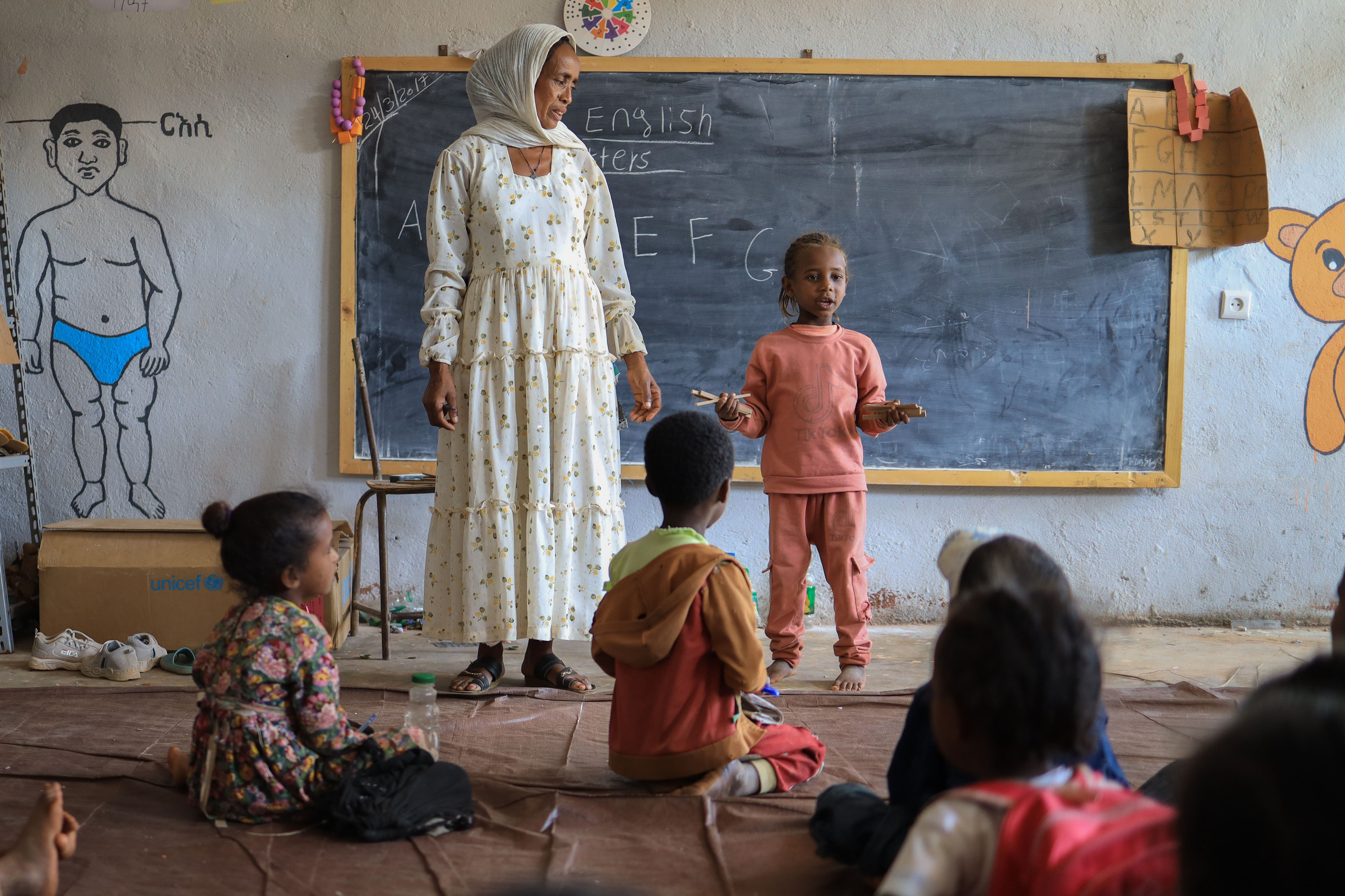schoolgirl with her teacher in a classroom in Ethiopia