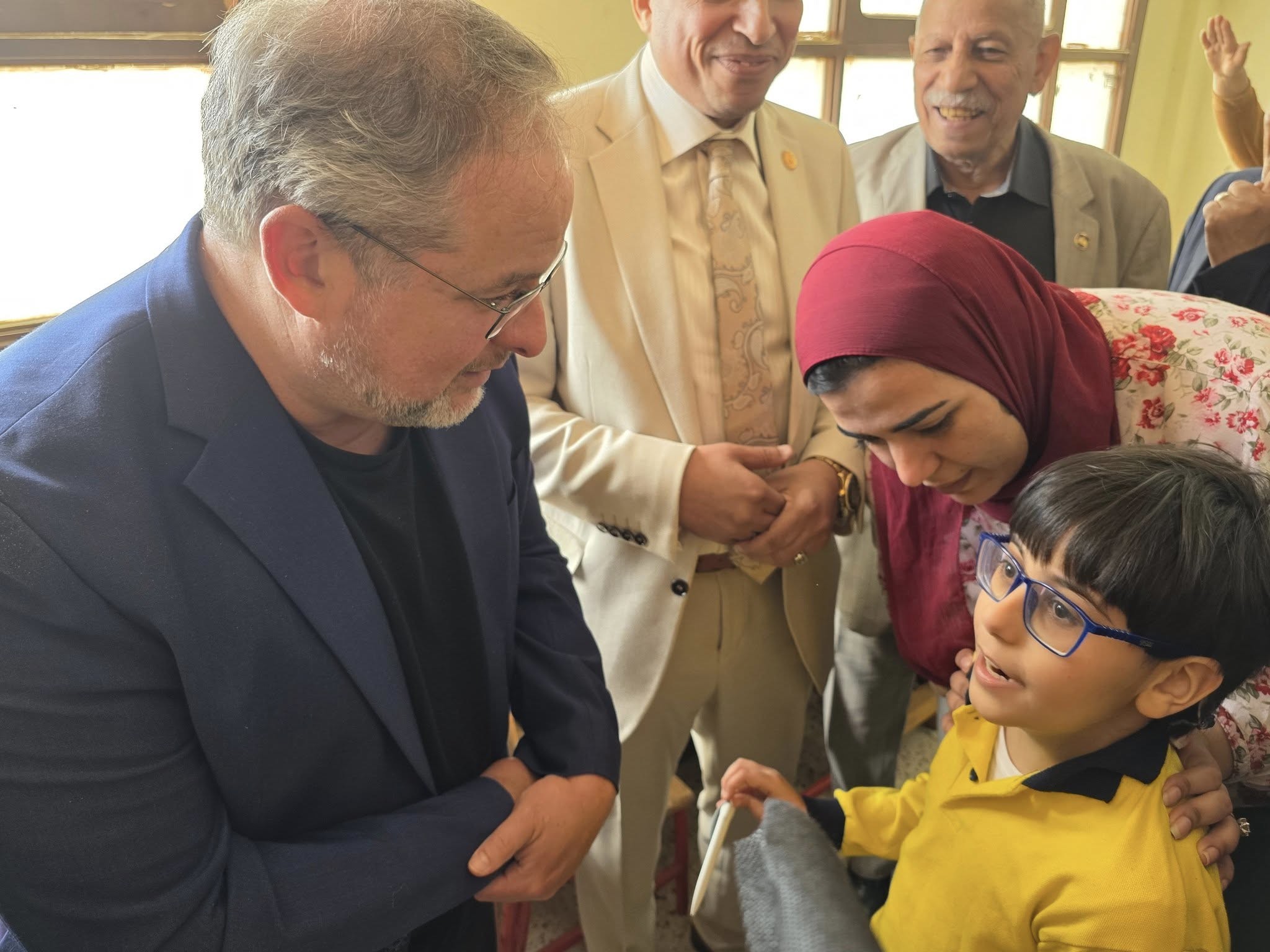 Dr. David Edwards engaging with a child surrounded by people